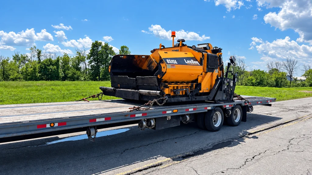 Construction machinery on a Transport JKM flatbed trailer