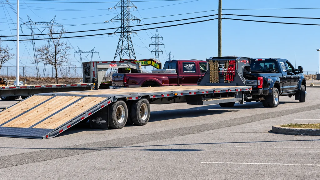 A Transport JKM flatbed trailer with its ramp lowered.