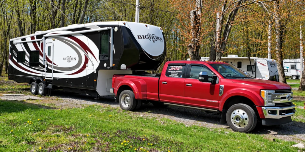 Fifth-wheel trailer loaded on a Transport JKM flatbed trailer