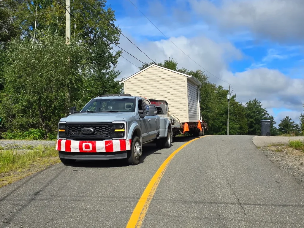 Camion de Transport JKM transportant un cabanon sur une remorque