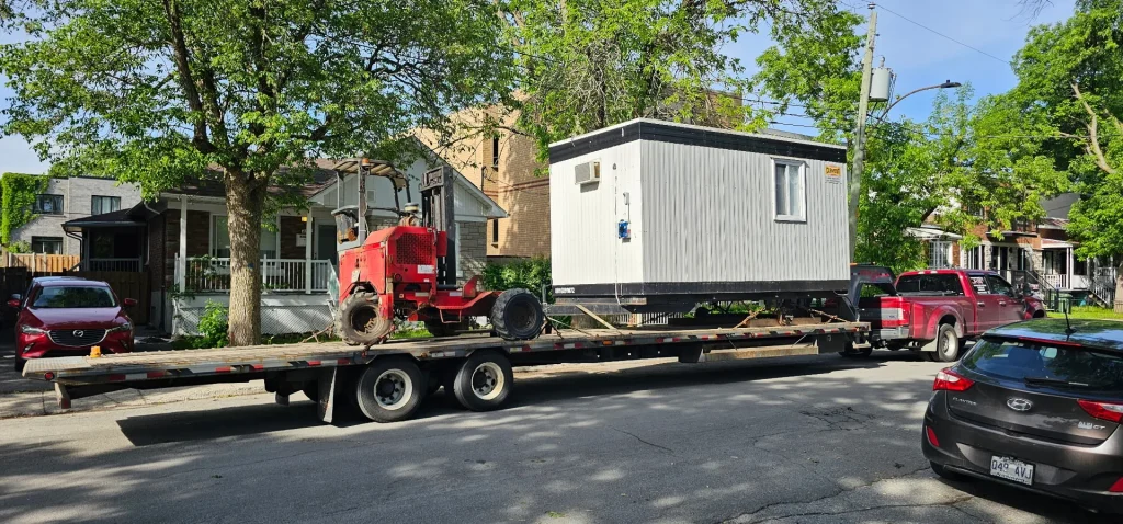 A white module and forklift on a Transport JKM trailer